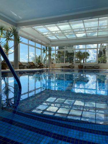 a large swimming pool with blue tiles in a building at Hotel Savoy in Opatija