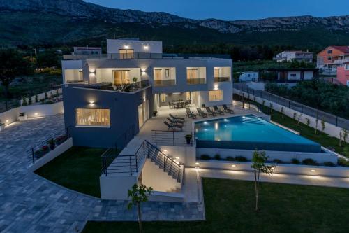 een villa met een zwembad in de nacht bij Luxurious Villa Meri in Kaštela