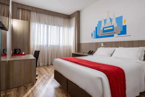 um quarto de hotel com uma cama grande e uma secretária em Ramada Encore by Wyndham São Paulo Osasco em Osasco