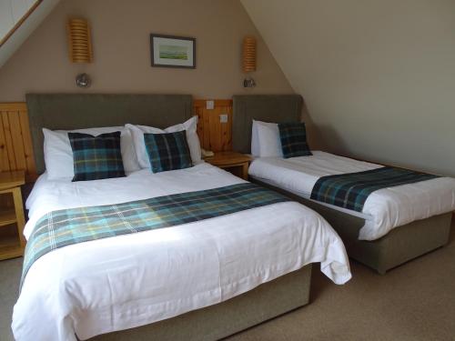 twee bedden in een kleine kamer met bij The Sands Hotel, Orkney in Burray Village