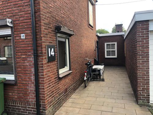 una bicicleta estacionada en un lado de un edificio de ladrillo en City Center Enschede Homestay en Enschede