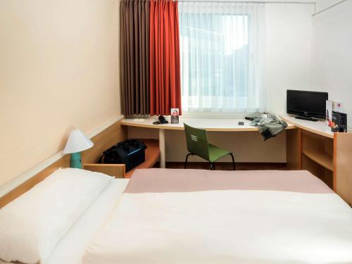 Habitación de hotel con cama y escritorio con ordenador en ibis Koblenz City, en Coblenza