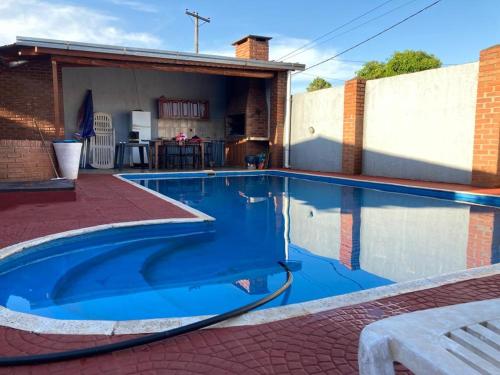 una piscina con agua azul en un patio trasero en Lo de Chawi en Puerto Iguazú