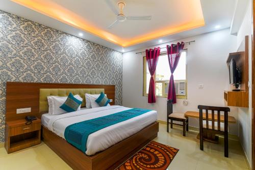 a bedroom with a bed and a television in it at Hotel Urban Tree At Delhi Airport in New Delhi