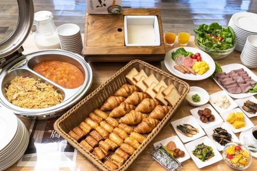 una mesa llena de comida y platos de comida en Hotel Mark-1 CNT en Inzai