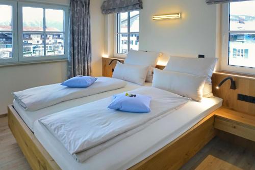 a bedroom with two beds with blue pillows on them at Lake Life 9 in Bad Wiessee