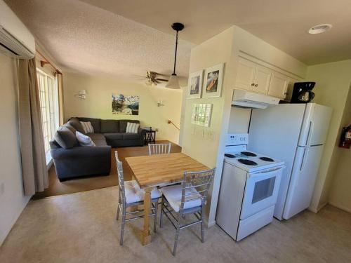 cocina y sala de estar con mesa y nevera en Becky's Condo, en Mariposa