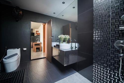 a bathroom with a tub and a toilet and a sink at Villa Mandi in Ban Thong Phlu