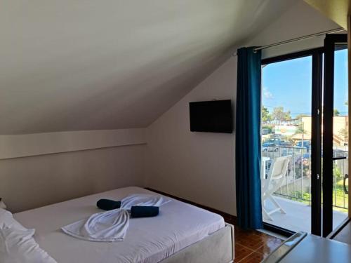 Schlafzimmer mit einem Bett und Blick auf einen Balkon in der Unterkunft Vila Lazri in Shëngjin