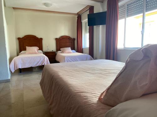 A bed or beds in a room at Hotel Medina Centro