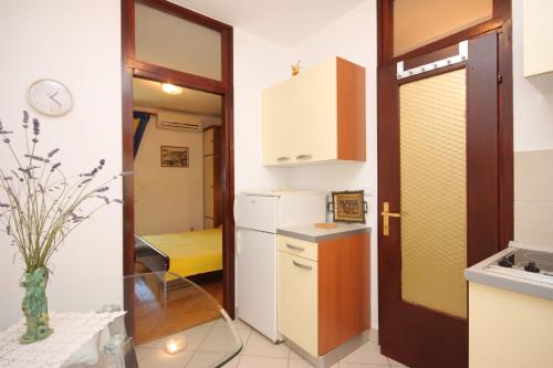 una pequeña cocina con una mesa de cristal y una puerta en Apartment Mali Losinj 7879b, en Mali Lošinj