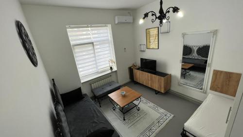 a living room with a table and a mirror at Apartmani Aurora in Tuzla