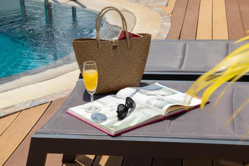 a table with a book and a glass of orange juice at Urbanite Hotel in Vientiane