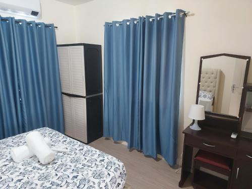 una camera da letto con tende blu, un letto e uno specchio di 3 bed 3 bath Friendly, Friendship area, Fibre bdb a Angeles