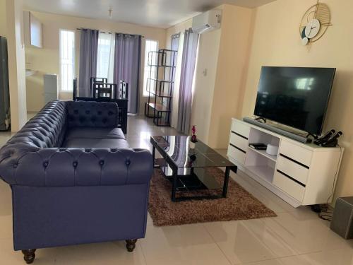 sala de estar con sofá y TV de pantalla plana en 3 bed 3 bath Friendly, Friendship area, Fibre bdb, en Ángeles