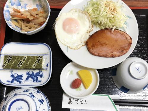 un plato de comida con un huevo en una mesa en Imazato Ryokan, en Osaka