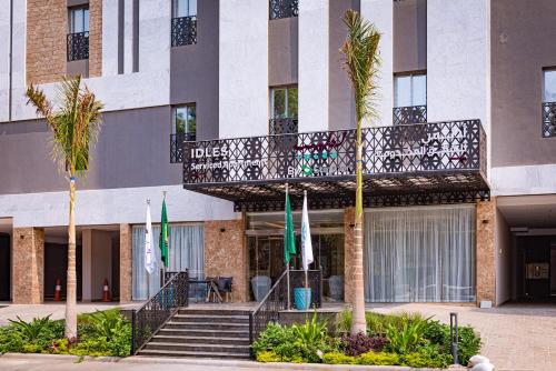 a hotel with a staircase and palm trees in front of it at idles By Staytion Serviced Apartments in Jeddah