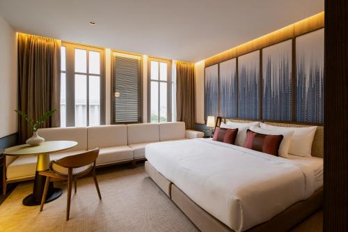 Hotel MOCO في أودون ثاني: غرفة فندقية بسرير كبير واريكة