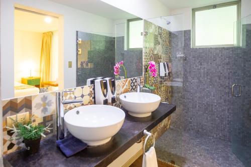ein Bad mit einem Waschbecken und einer Dusche in der Unterkunft La Vela Boutique Hotel in Manuel Antonio