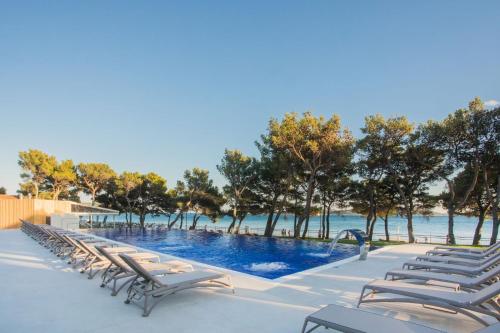 una fila di sedie a sdraio accanto alla piscina di Villa Arausa a Vodice