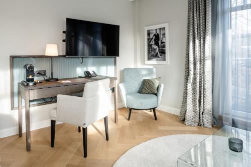 a room with a desk and a chair and a television at Clounys Hotel in Hamburg