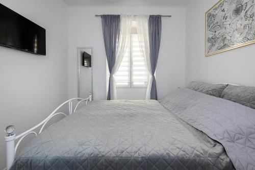 a bedroom with a bed and a window at Apartman Žana in Opatija