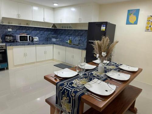 una cocina con una mesa con platos y copas de vino en 4 Bedroom Bungalow, Angeles City en Ángeles