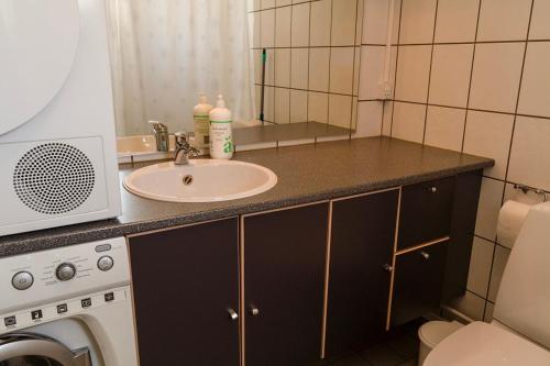 een badkamerbar met een wastafel en een spiegel bij Hotel Nuka in Ilulissat