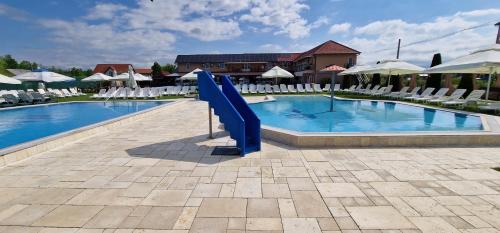 a swimming pool with a blue slide in a resort at Motel LAGUNA in Beiuş