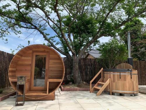 un petit sauna en bois à côté d'un arbre dans l'établissement 旭日山荘, 