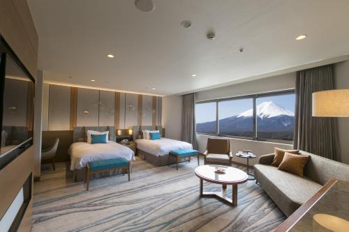 um quarto de hotel com duas camas e um sofá em Highland Resort Hotel & Spa em Fujiyoshida