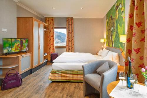 una camera d'albergo con letto e TV di Weinhotel Landsknecht a Sankt Goar