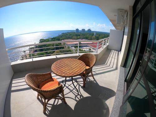 een balkon met 2 tafels en stoelen en de oceaan bij Tropical Executive Hotel in Manaus