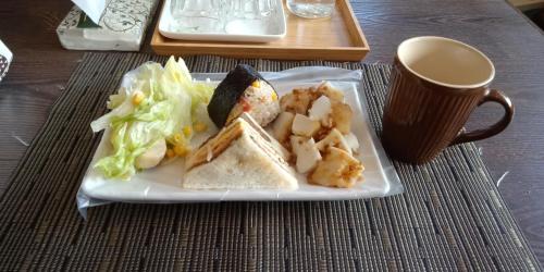 een bord met een broodje en salade en een kopje koffie bij Guiju Lin Garden Homestay in Nanzhuang