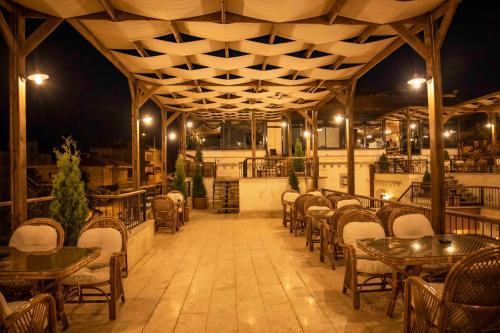 un restaurante vacío con mesas y sillas por la noche en Garden Suites Hotel Cappadocia en Goreme