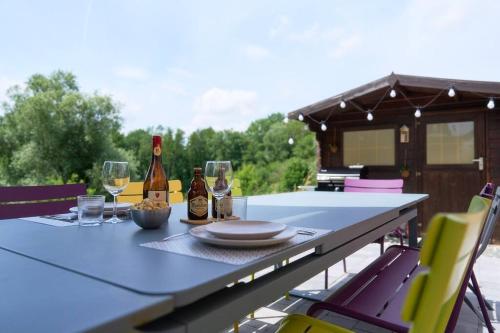 una mesa con dos botellas de vino y copas en La Reserve en Brugelette