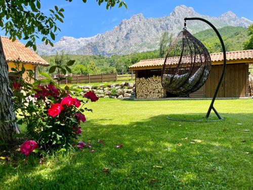 un columpio en un patio con montañas al fondo en Hotel Eigón, en Posada de Valdeón