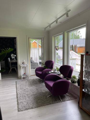 een woonkamer met paarse stoelen en een tafel bij Leilighet med 2 soverom in Rokland