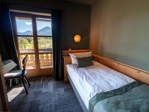 - une petite chambre avec un lit et une fenêtre dans l'établissement Berghotel Sonnenbichl, à Bad Wiessee