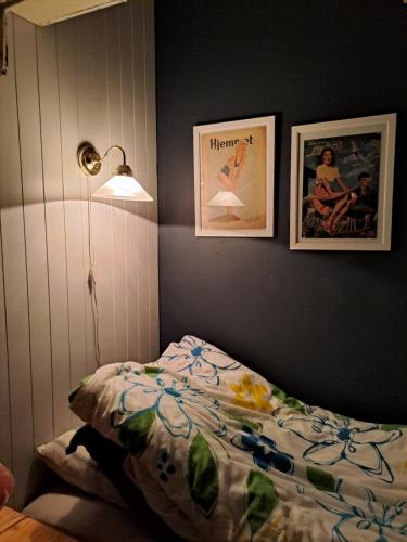 ein Schlafzimmer mit einem Bett und zwei Bildern an der Wand in der Unterkunft Kule gule huset in Svolvær