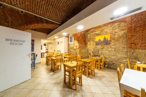 ein Restaurant mit Holztischen und -stühlen und Ziegelwand in der Unterkunft Minimino hotel in Prag