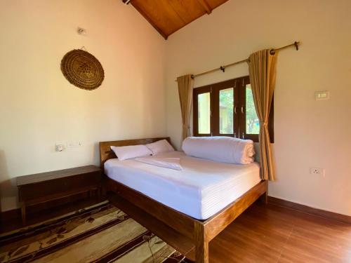 a small bedroom with a bed with a window at Bardia Eco Friendly Homestay in Bhurkīā