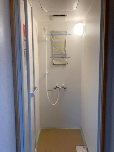 a bathroom with a shower with a towel at Nostime lodge 女性限定 female only in Kitakyushu