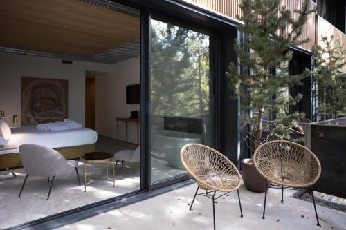 - une chambre avec des portes et des chaises en verre dans l'établissement BOX ART ALPINO, à Navacerrada