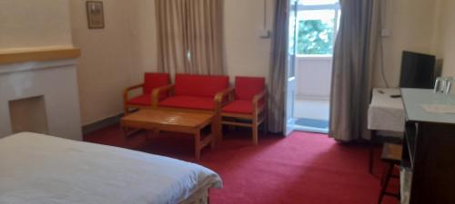 een hotelkamer met een bed, een stoel en een tafel bij BRIGHTLANDS HOTEL in Murree