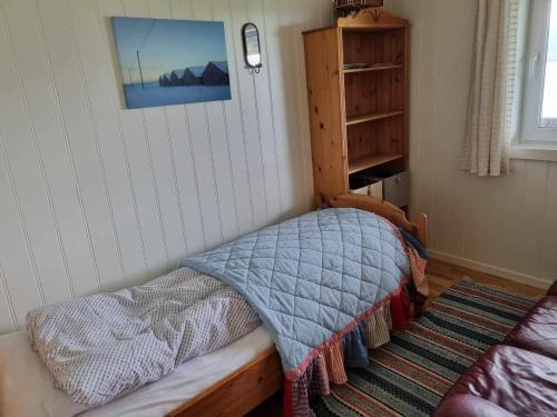 a small bedroom with a bed with a blanket at Rekdal in Vestnes