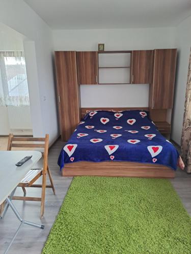 1 dormitorio con cama y alfombra verde en Vila Bulgaru en Cumpăna