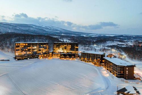 een groep gebouwen in de sneeuw op een berg bij Park Hyatt Niseko Hanazono in Kutchan