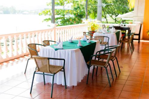 a row of tables with white and green tablecloths at Hotel Villa del Lago in Flores