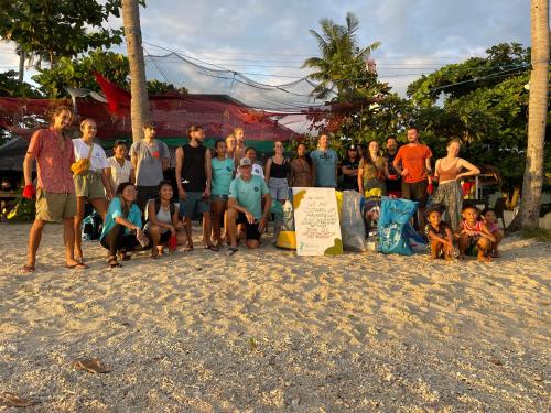 un grupo de personas posando para una foto en la playa en Tribal Huts Community, en Daanbantayan